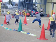 芝生でゴムとびをする幼児の写真