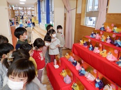 製作したひな人形を見ている幼児の写真