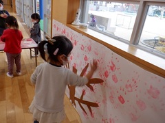 手形で桜を作っている幼児の写真