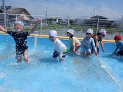 プールで水遊びをする幼児の写真