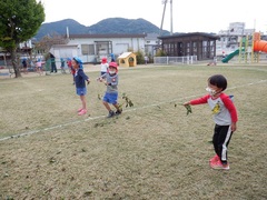 さつまいもの芋ずるで遊ぶ幼児の写真