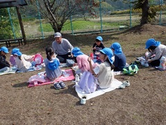 公園でお弁当を食べる幼児の写真