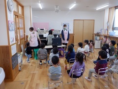 保護者の読み聞かせを聞いている幼児の写真