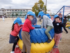 小学校の校庭で遊ぶ幼児の写真