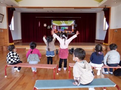 発表会のビデオを見ている幼児の写真