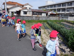 園外保育に出掛け公園まで歩いている幼児の写真