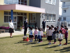 芝生で新しく赴任した先生の紹介をしている写真