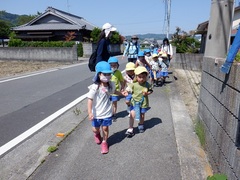 園外保育で公園まで歩く幼児の写真