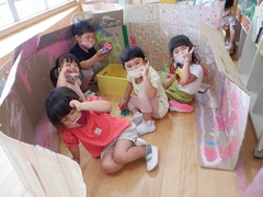 段ボールで遊ぶ幼児の写真