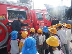 消防自動車を見学する幼児の写真