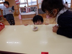 コマで遊んでいる幼児の写真