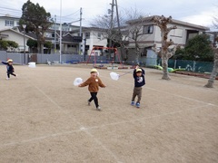 ポリ袋で作った凧で遊ぶ幼児の写真