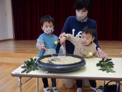 豆煎りをしている幼児の写真