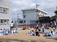 園庭でお弁当を食べる幼児の写真