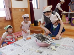 野菜の皮むきをしている幼児の写真