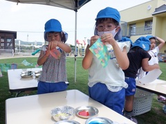 浸し染めをして遊ぶ幼児の写真