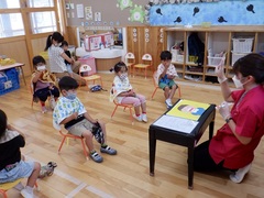 歯磨きについての話を聞いている幼児の写真