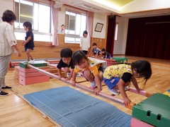 ホールの巧技台で遊ぶ幼児の写真