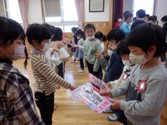 お別れ会のプレゼント交換をする幼児の写真