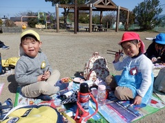 公園で弁当を食べる幼児の写真