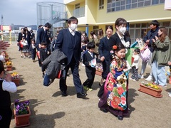 卒園式の見送りをする幼児の写真