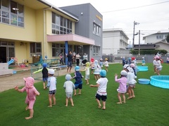 水遊び前の体操をする幼児の写真