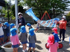 手作りの大きなこいのぼりを飾る幼児の写真