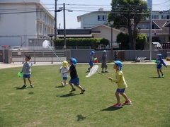 芝生園庭で遊んでいる幼児の写真