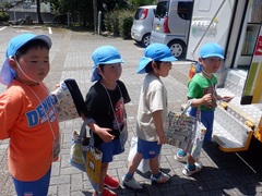 移動図書館で絵本を借りる幼児の写真