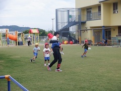 園庭で遊ぶ幼児と教育実習生の写真