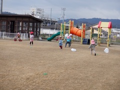 園庭でたこあげをしている幼児の写真