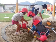 砂場で遊んでいる幼児の写真