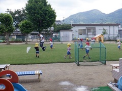 芝生園庭で遊ぶ幼児の写真