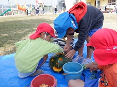 カボチャの飾りを作る幼児の写真