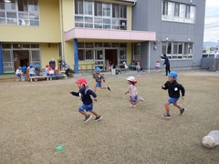 園庭で遊んでいる幼児の写真