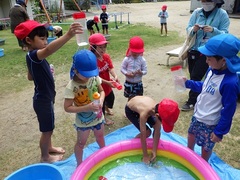 小学生と水遊びをする様子