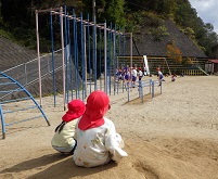 小学生の鉄棒の授業を見ている幼児