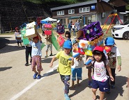 手作り神輿を担いで、小学生の獅子と太鼓に合わせて歩く