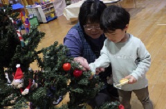 先生と一緒に飾る幼児