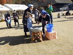 もちつきをする幼児と保護者