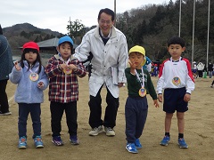 メダルを掛けた幼児と園長先生