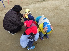 頭を隠して座る幼児