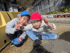 大きな氷に顔をうつしてみる幼児たち