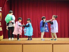 踊りで友達と手を合わせる幼児