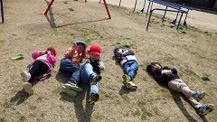 芝生で寝転がる幼児たち