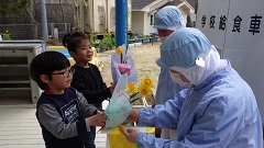 給食センターの方に手紙と花束を渡す幼児