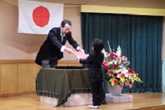 卒園証書を園長先生からいただく幼児