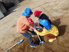 土山をスコップで掘る幼児