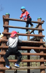 アスレチック遊具にのぼる幼児