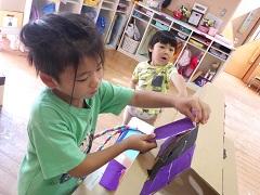 手作りみこしの屋根を作る幼児